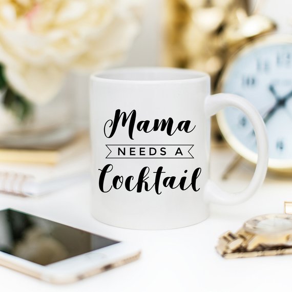 A humorous coffee mug with the text 'Mama Needs A Cocktail', showcasing a fun design perfect for Mother's Day gifts.