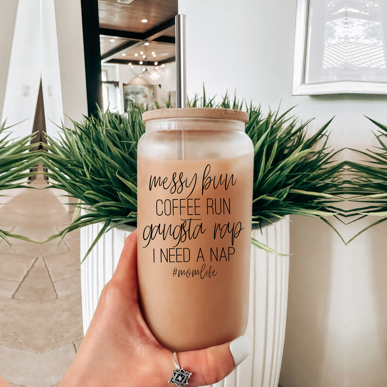 A stylish Messy Bun glass drinking cup with a bamboo lid and stainless steel straws, perfect for hot and cold beverages.