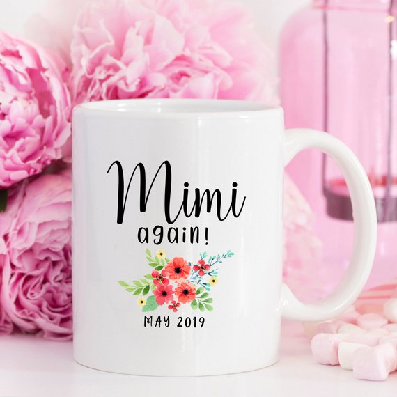 White ceramic mug with pregnancy announcement design printed on both sides, perfect for new moms.