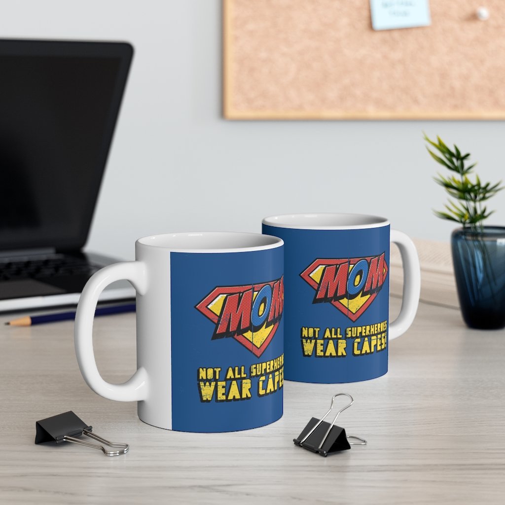 A white ceramic mug featuring the phrase 'Not All Superheroes Wear Capes' with a superhero theme, perfect for coffee or tea.