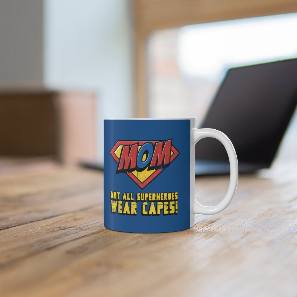 A white ceramic mug featuring the phrase 'Not All Superheroes Wear Capes' with a superhero theme, perfect for coffee or tea.