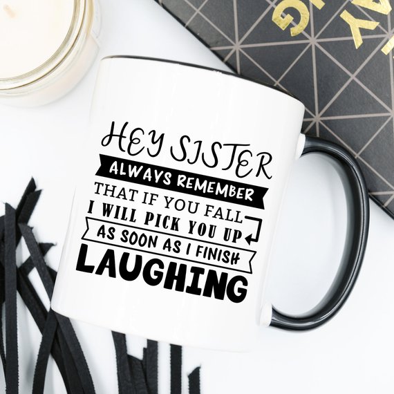 Funny coffee mug for sisters with a humorous quote, featuring a vibrant design on a white ceramic background.