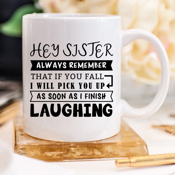 Funny coffee mug for sisters with a humorous quote, featuring a vibrant design on a white ceramic background.