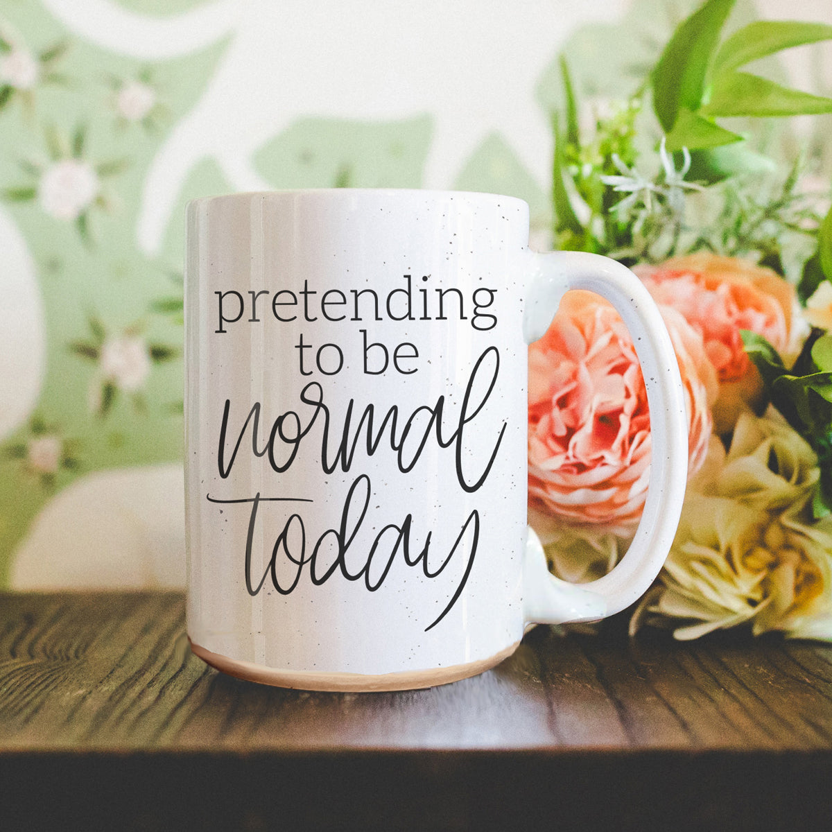 A 16oz off-white ceramic mug with dark speckles, featuring the humorous text 'Pretending to be Normal Today' on both sides.