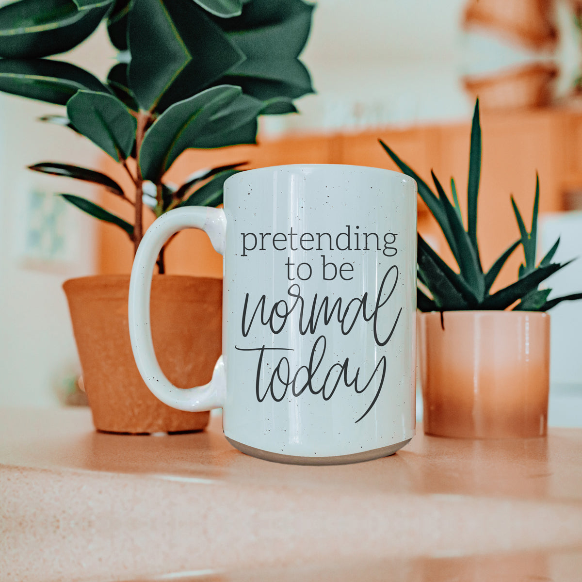 A 16oz off-white ceramic mug with dark speckles, featuring the humorous text 'Pretending to be Normal Today' on both sides.