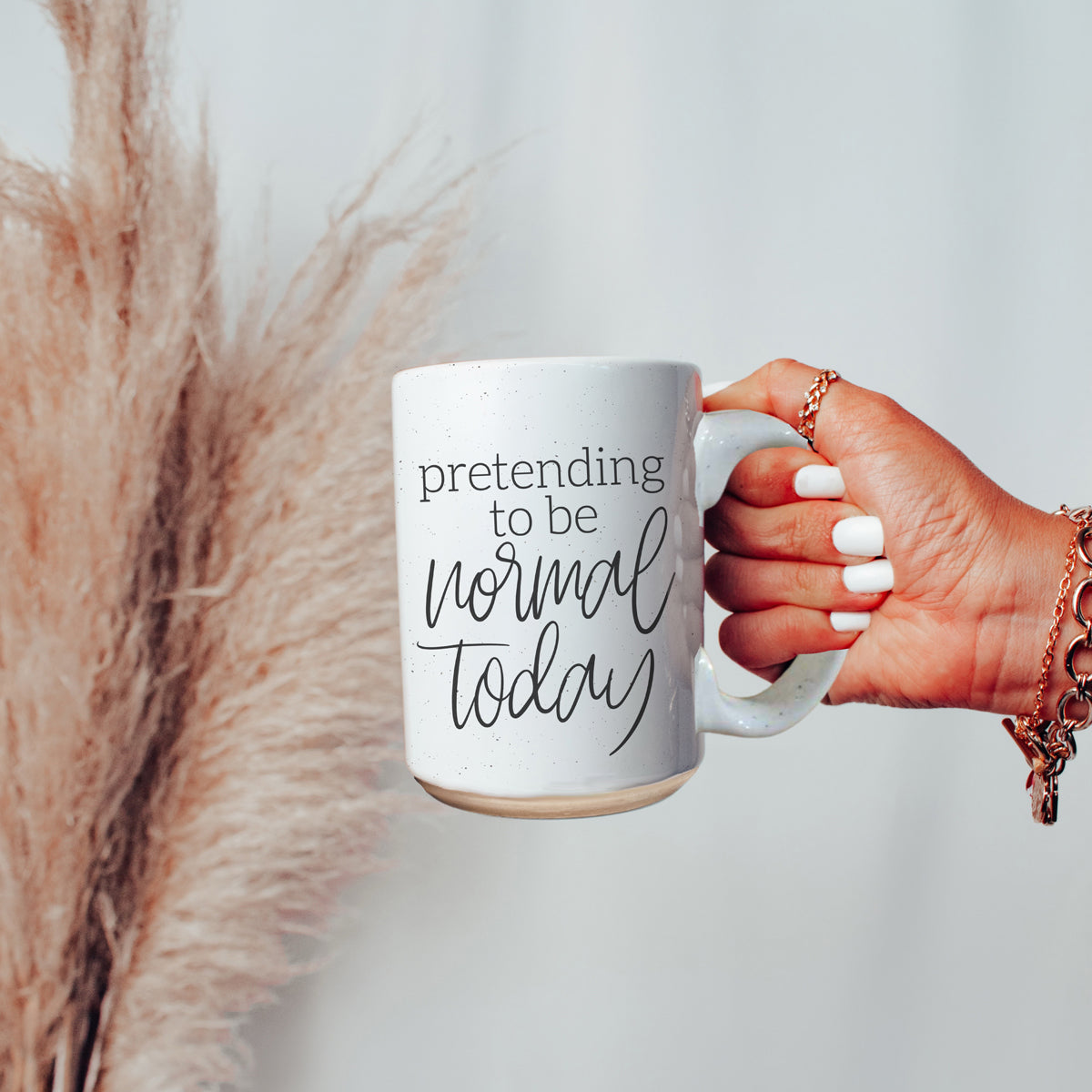 A 16oz off-white ceramic mug with dark speckles, featuring the humorous text 'Pretending to be Normal Today' on both sides.