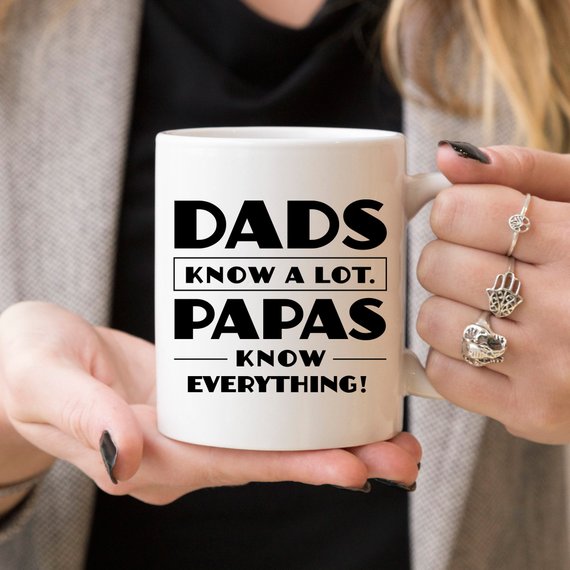 Funny coffee mug with the phrase 'Dads Know A Lot, Papas Know Everything' printed on it, showcasing a humorous design perfect for gifting.