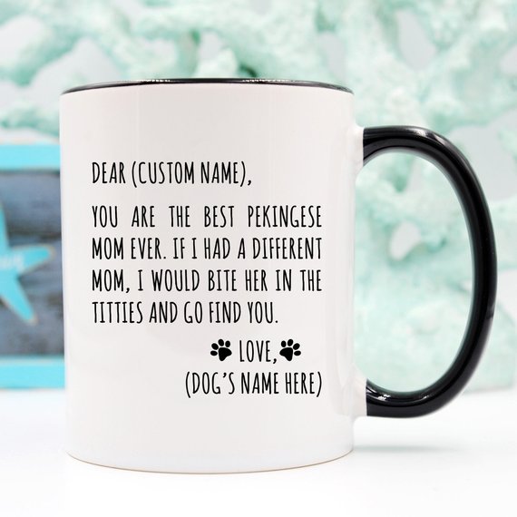 A white ceramic mug featuring a vibrant Pekingese design, available in 11 and 15 oz sizes, showcasing the love for Pekingese moms.