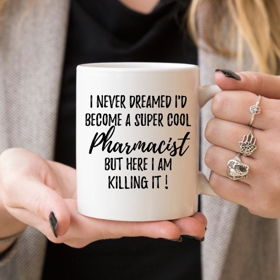 A stylish white ceramic mug designed for pharmacists, featuring a vibrant printed design on both sides, perfect for coffee or tea.