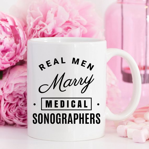 A humorous coffee mug featuring the phrase 'Real Men Marry Medical Sonographers', showcasing a fun design perfect for gifts.