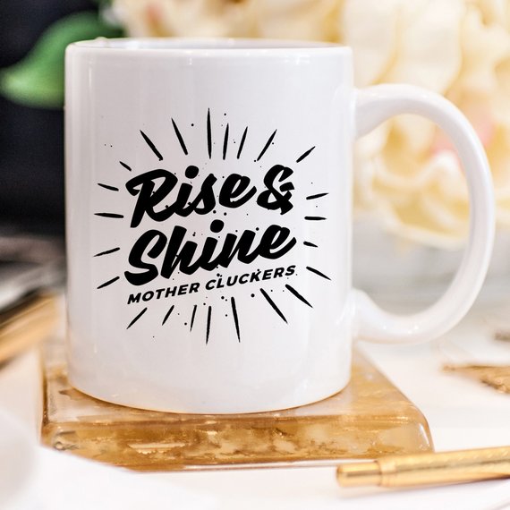 Rise and Shine Mother Cluckers Funny Coffee Mug featuring a humorous design, perfect for coffee or tea lovers.