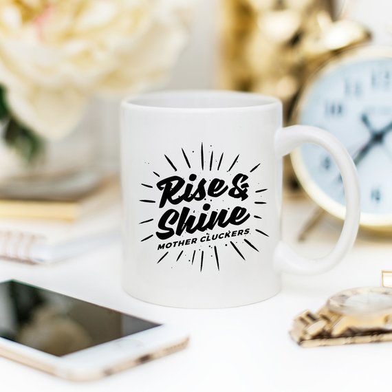 Rise and Shine Mother Cluckers Funny Coffee Mug featuring a humorous design, perfect for coffee or tea lovers.