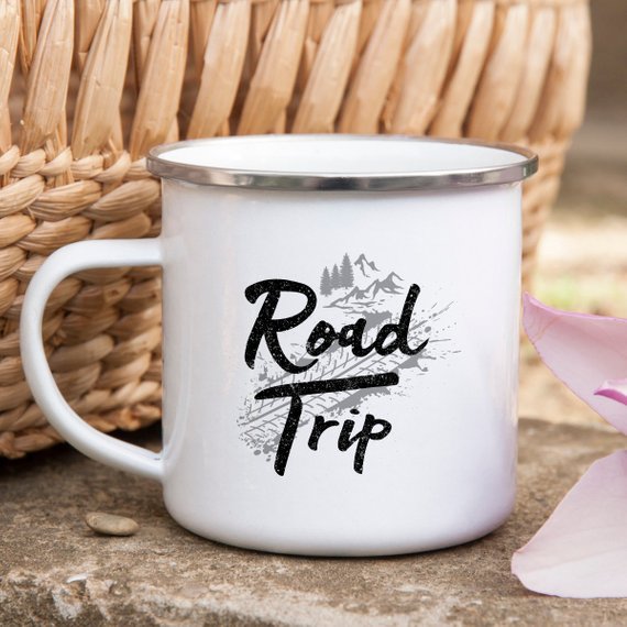 A white enamel camping mug with a stainless steel rim, featuring a vibrant road trip design printed on both sides, perfect for outdoor adventures.