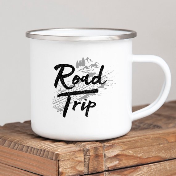 A white enamel camping mug with a stainless steel rim, featuring a vibrant road trip design printed on both sides, perfect for outdoor adventures.