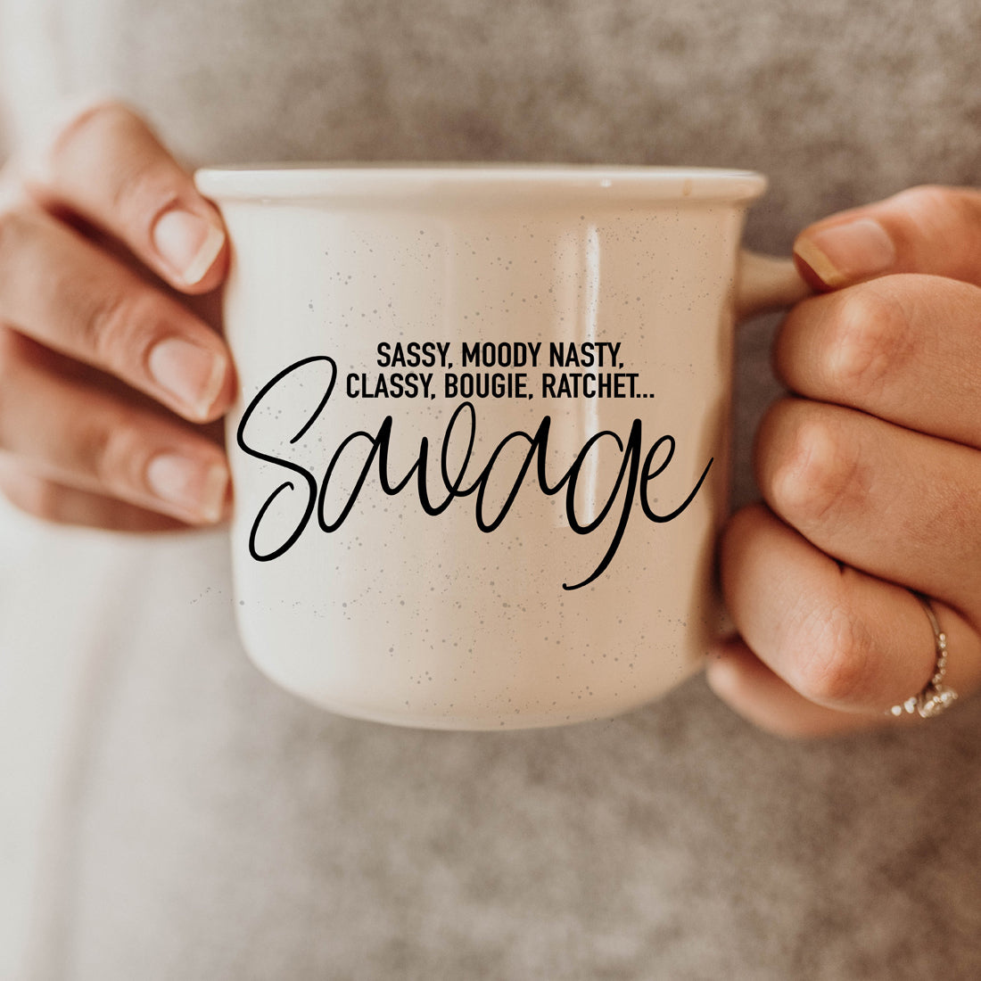 Sassy Savage 14.5oz ceramic mug with black lettering on a light ivory background, featuring a rustic campfire style design.