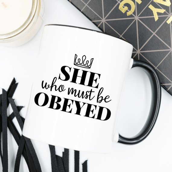 A humorous coffee mug with the phrase 'She Who Must Be Obeyed' printed on it, made from high-quality ceramic.