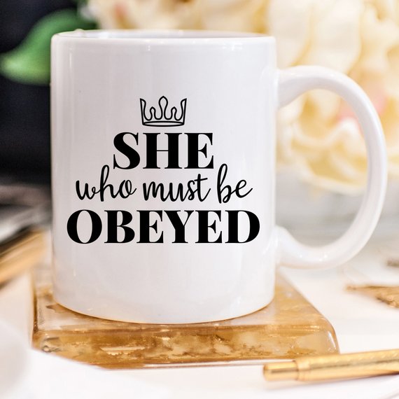 A humorous coffee mug with the phrase 'She Who Must Be Obeyed' printed on it, made from high-quality ceramic.