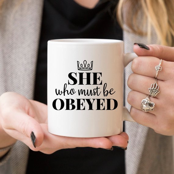 A humorous coffee mug with the phrase 'She Who Must Be Obeyed' printed on it, made from high-quality ceramic.