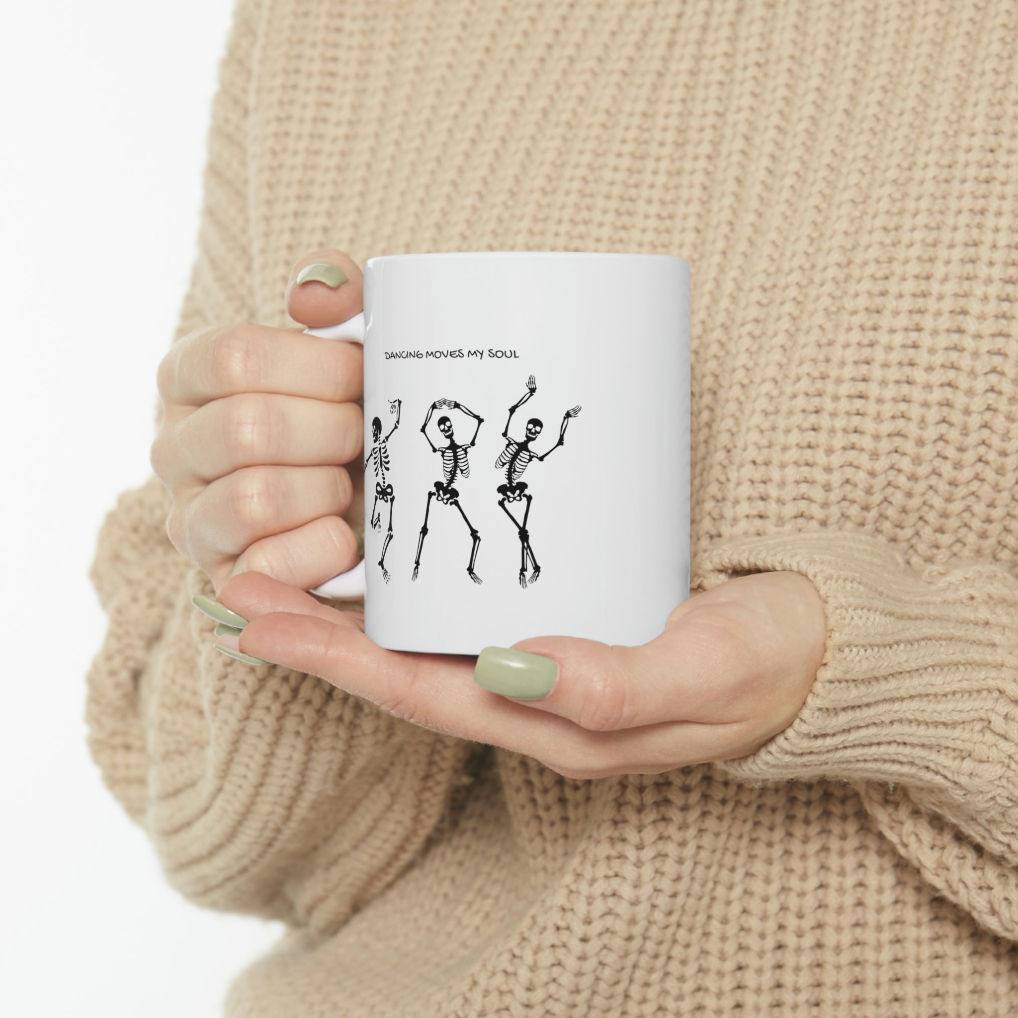 A white ceramic mug featuring a playful design of dancing skeletons, perfect for coffee and tea lovers.