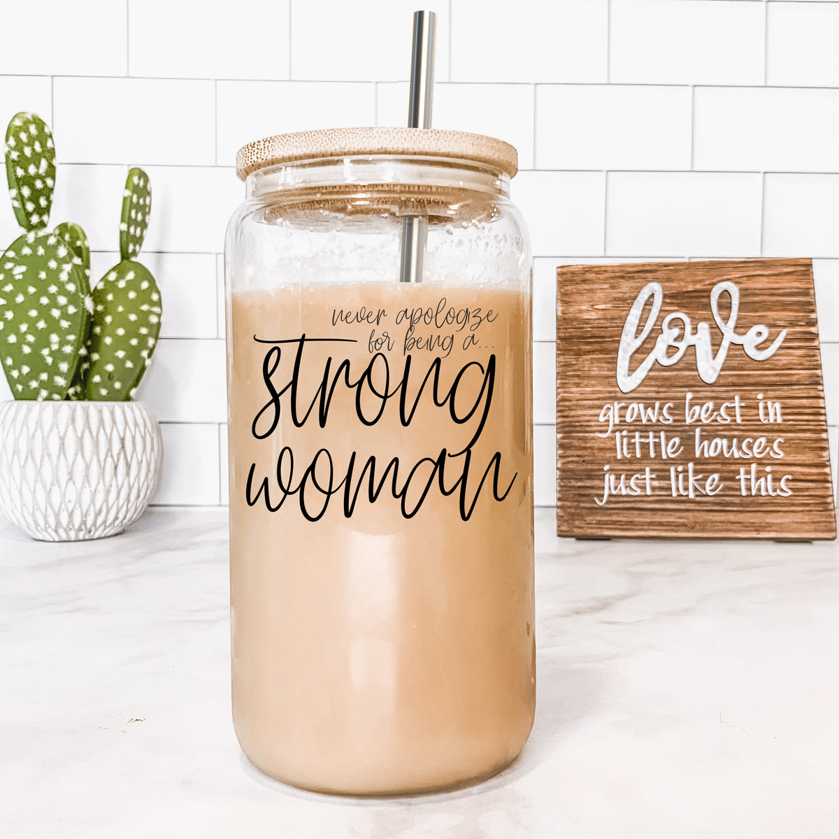 Strong Woman Set featuring glass drinking cups with bamboo lids and stainless steel straws, showcasing a stylish black graphic design.