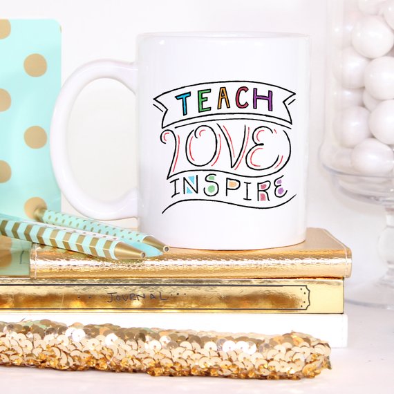 A ceramic coffee mug featuring the phrase 'Teach Love Inspire' in a fun design, perfect for teachers.