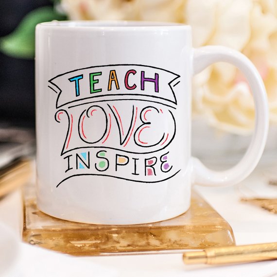 A ceramic coffee mug featuring the phrase 'Teach Love Inspire' in a fun design, perfect for teachers.