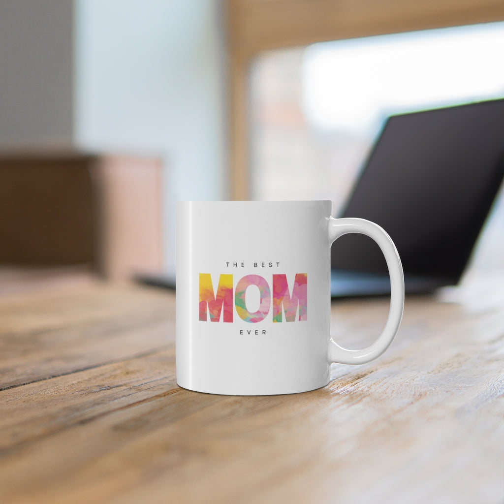 A white ceramic mug with 'The Best Mom' printed on it, featuring a C-handle and rounded corners, ideal for coffee or tea.