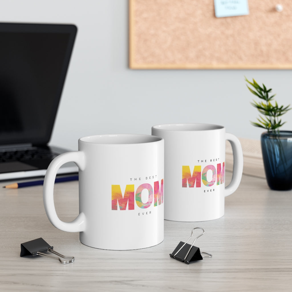 A white ceramic mug with 'The Best Mom' printed on it, featuring a C-handle and rounded corners, ideal for coffee or tea.