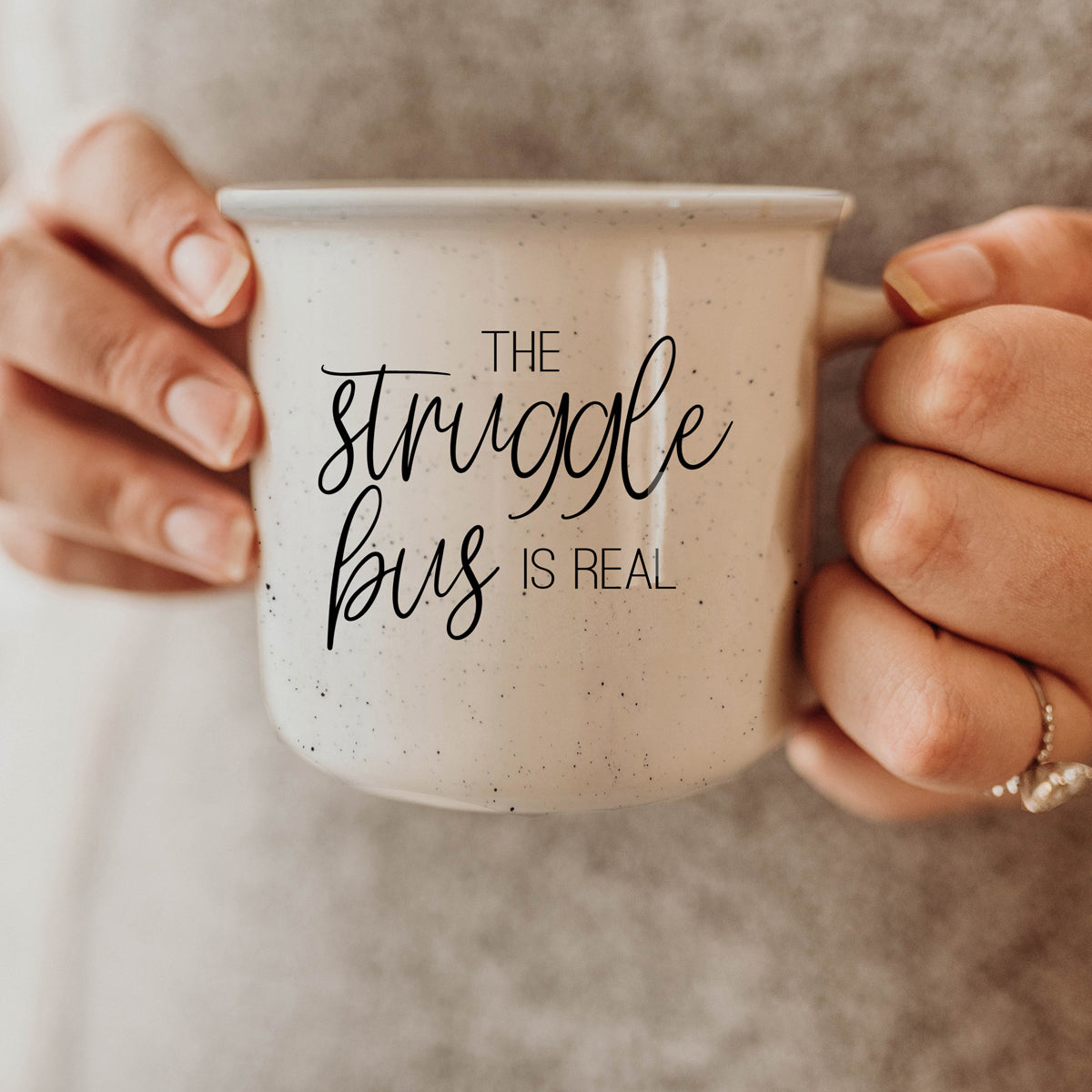 The Struggle 14.5oz ceramic campfire mug with light ivory speckles and black lettering, designed for comfort and style.