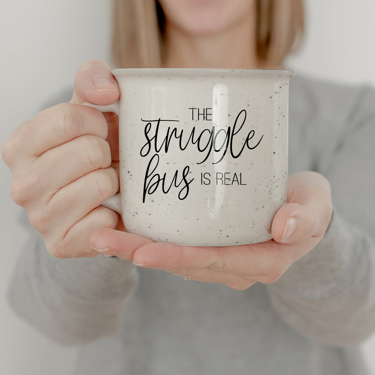 The Struggle 14.5oz ceramic campfire mug with light ivory speckles and black lettering, designed for comfort and style.