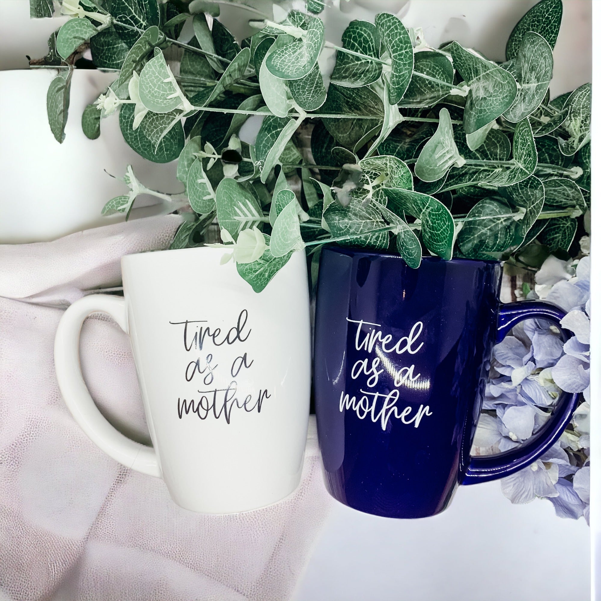 Tired as a Mother Grande mug in navy blue and white, featuring double-sided design with humorous text, perfect for mothers.