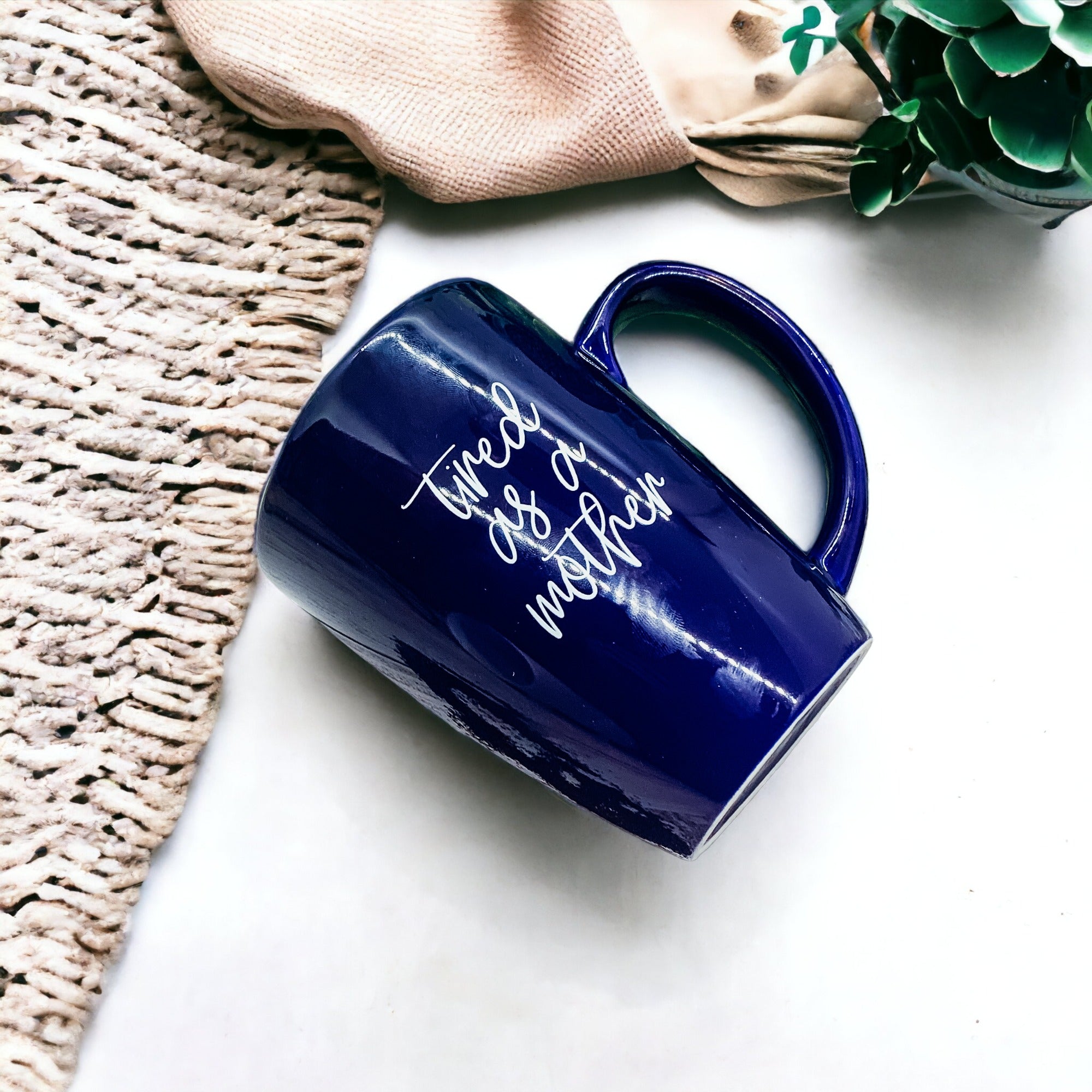 Tired as a Mother Grande mug in navy blue and white, featuring double-sided design with humorous text, perfect for mothers.