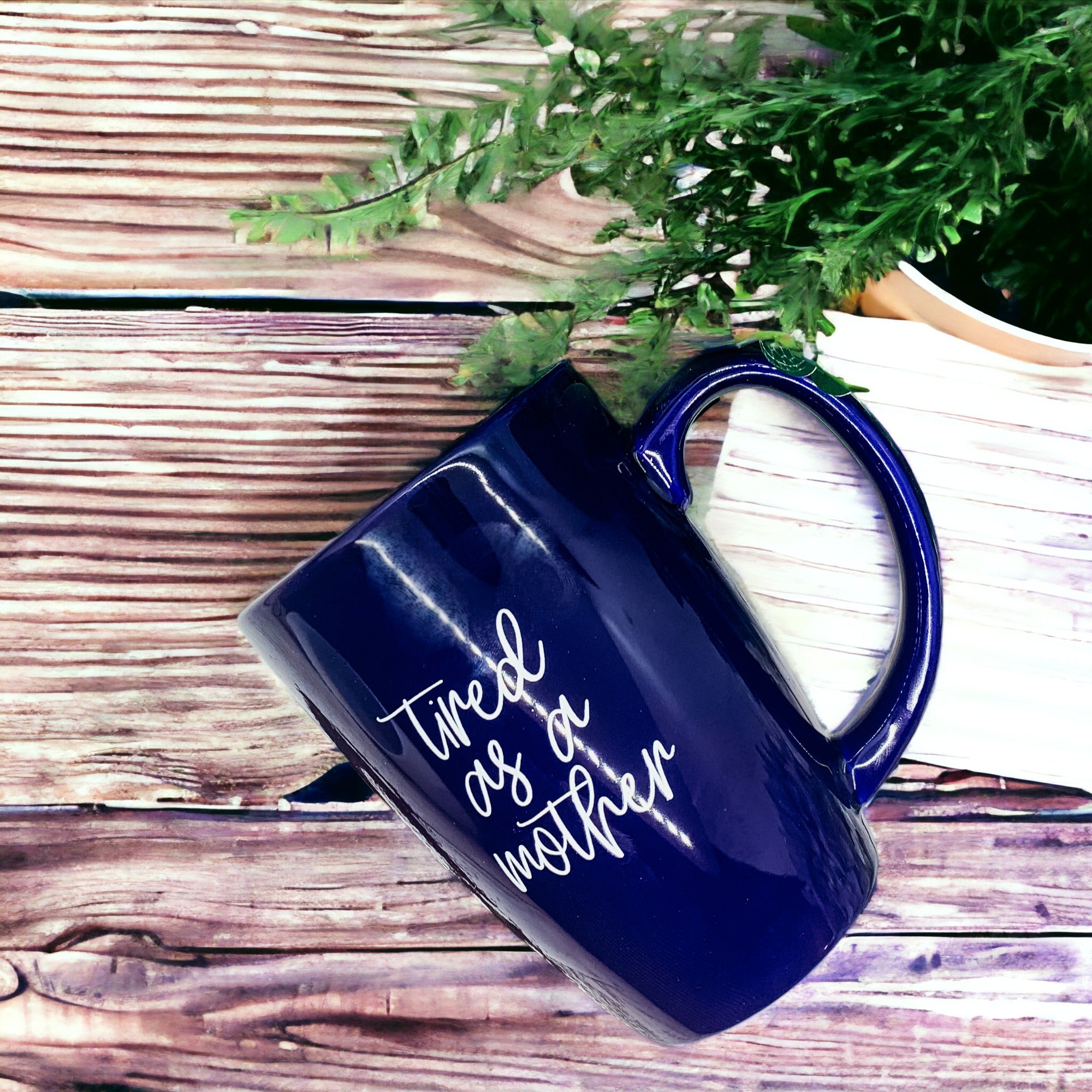 Tired as a Mother Grande mug in navy blue and white, featuring double-sided design with humorous text, perfect for mothers.