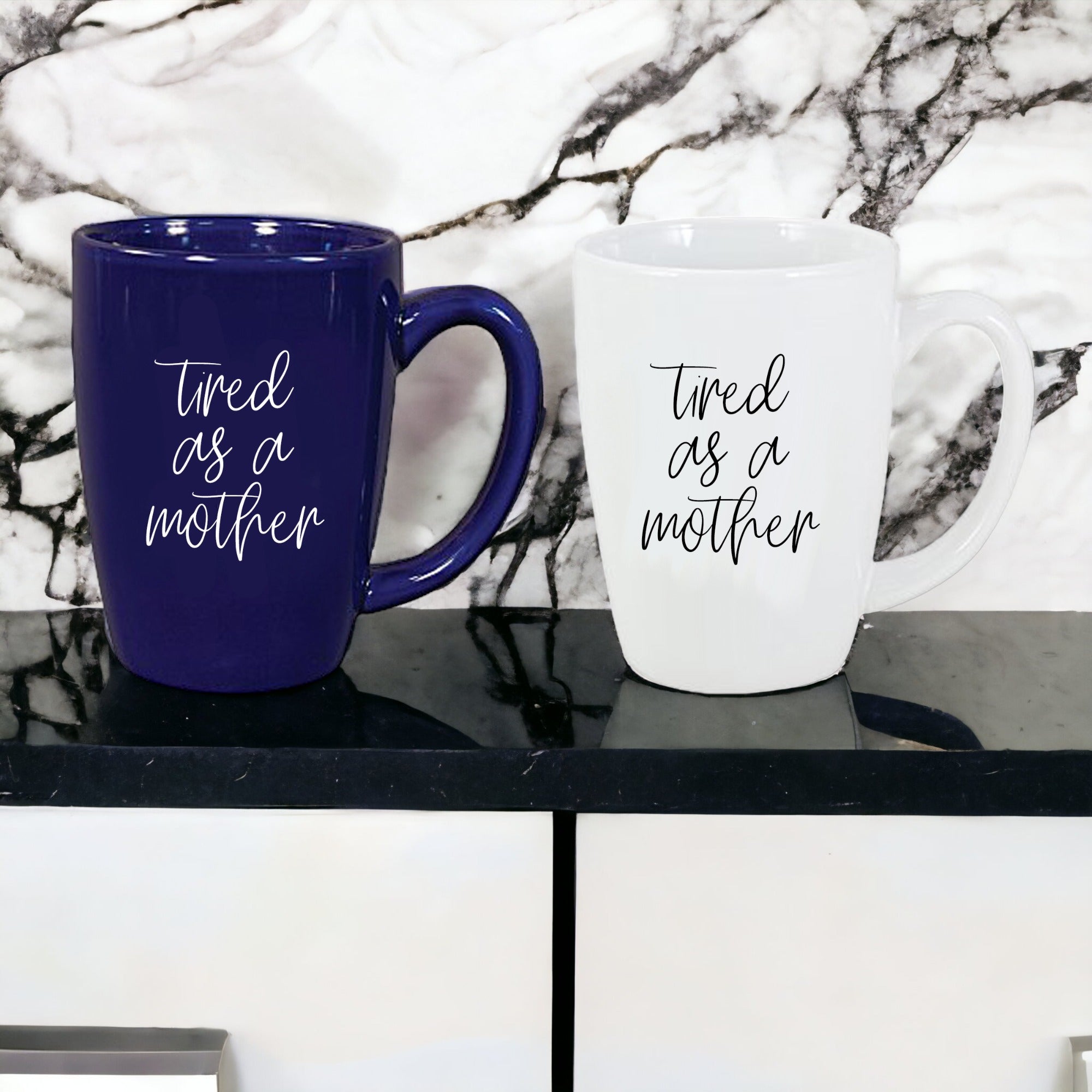 Tired as a Mother Grande mug in navy blue and white, featuring double-sided design with humorous text, perfect for mothers.