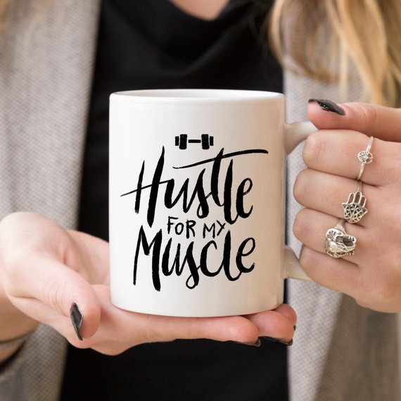 Hustle For The Muscle funny coffee mug featuring a humorous fitness design, perfect for coffee lovers and gym enthusiasts.