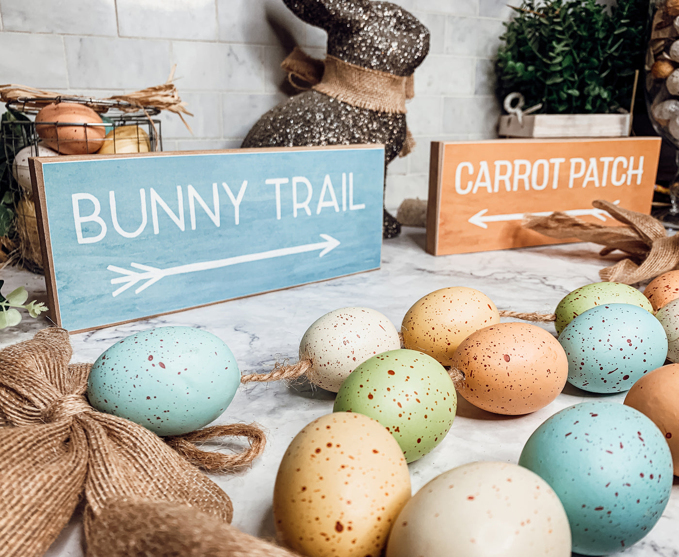 Two wooden block signs featuring Bunny Trail and Carrot Patch designs in pastel colors, perfect for Easter decor.