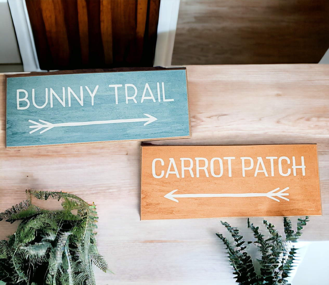 Two wooden block signs featuring Bunny Trail and Carrot Patch designs in pastel colors, perfect for Easter decor.