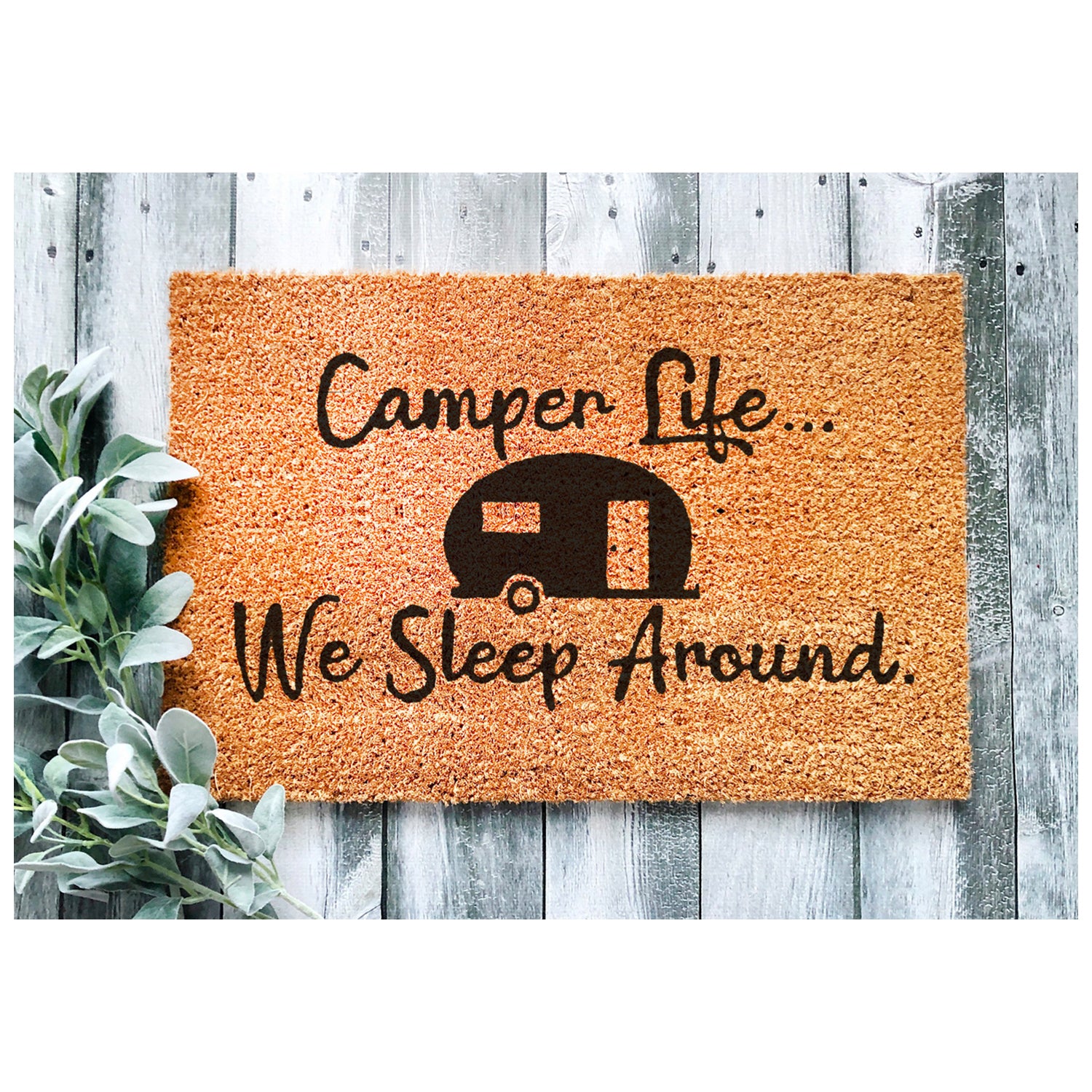 A humorous doormat with the phrase 'We Sleep Around', made of coir, perfect for camping entrances.