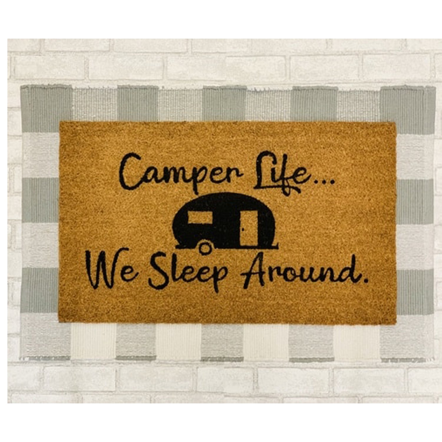 A humorous doormat with the phrase 'We Sleep Around', made of coir, perfect for camping entrances.