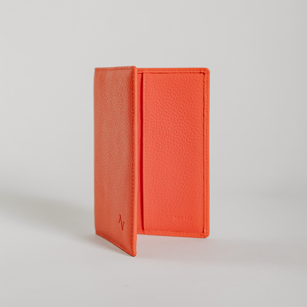 Coral Pebble Passport Holder made from durable leather with monogram personalization options and multiple card slots.