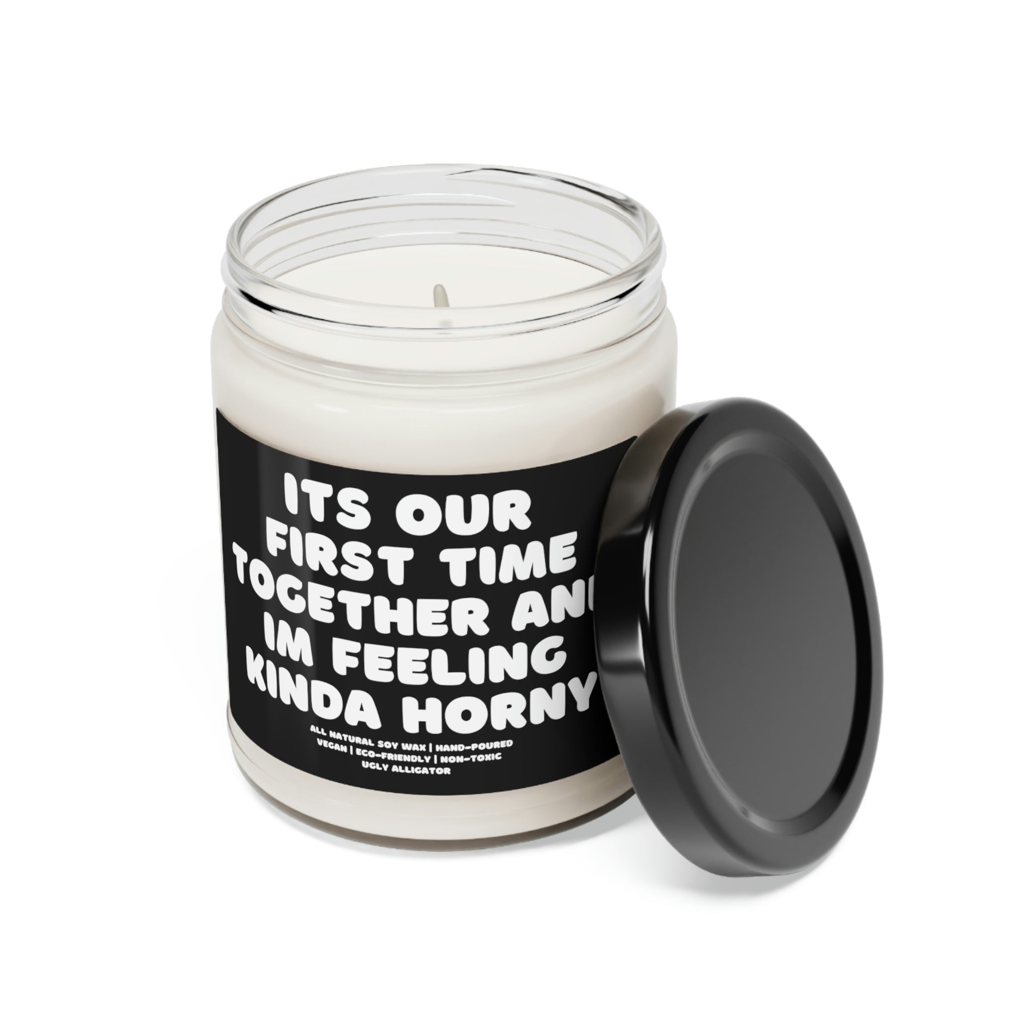 A stylish 9oz glass jar soy candle labeled 'It's Our First Time Together And I'm Feeling Kinda Horny', showcasing its elegant design and inviting aroma.