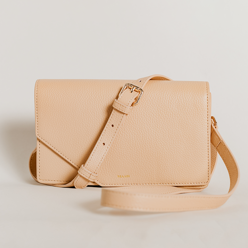 Match Sandy Nude Asymmetric Crossbody bag featuring smooth pebble leather and suede lining, with an adjustable strap and interior pocket.