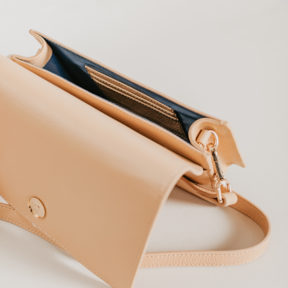 Match Sandy Nude Asymmetric Crossbody bag featuring smooth pebble leather and suede lining, with an adjustable strap and interior pocket.