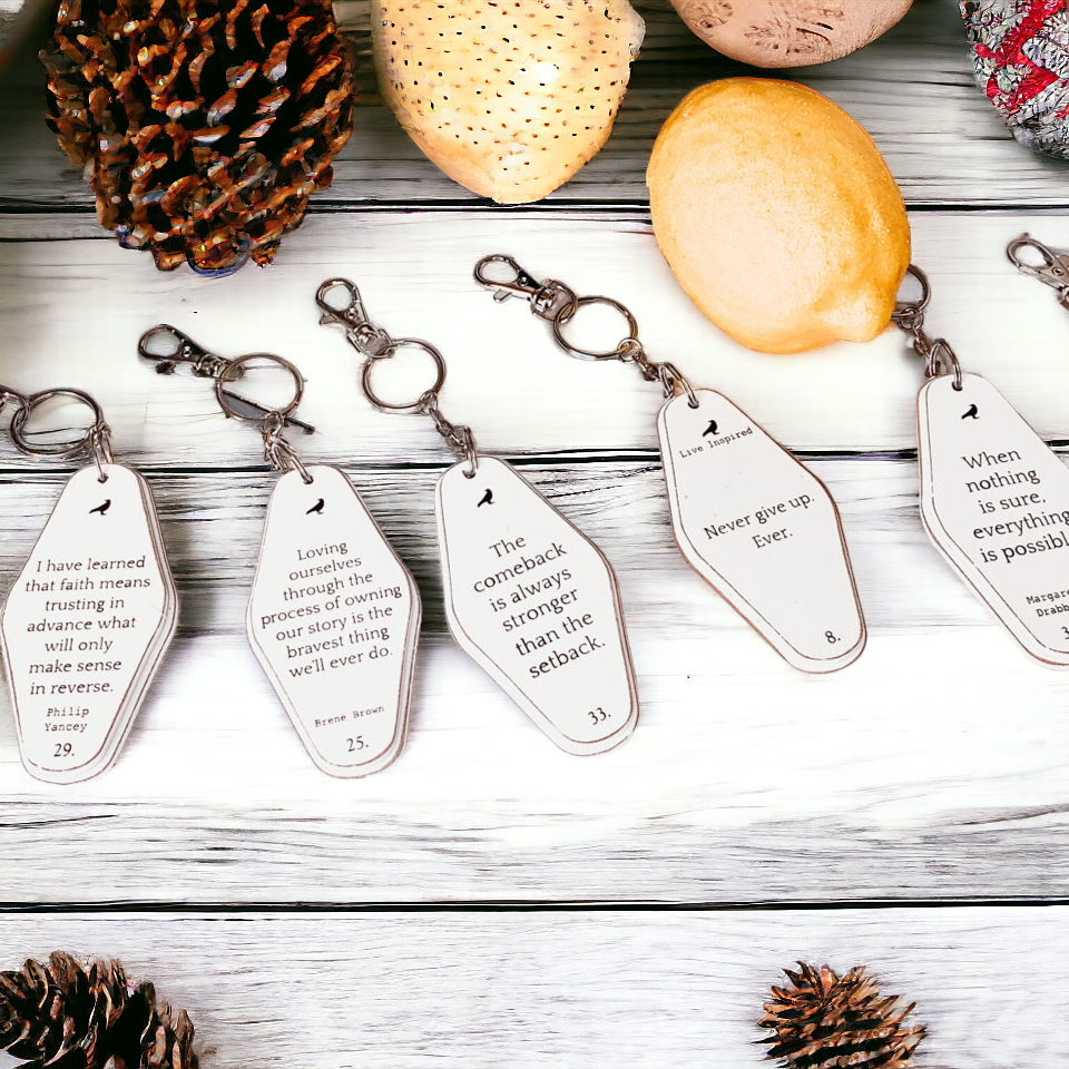 A collection of wooden key chains featuring various inspirational quotes, showcasing their durable design and stylish black and white colors.