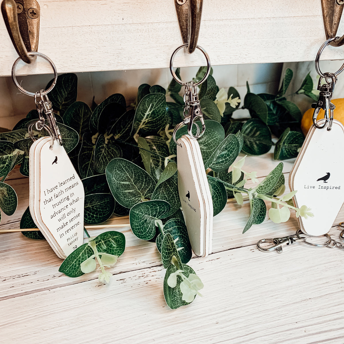 A collection of wooden key chains featuring various inspirational quotes, showcasing their durable design and stylish black and white colors.