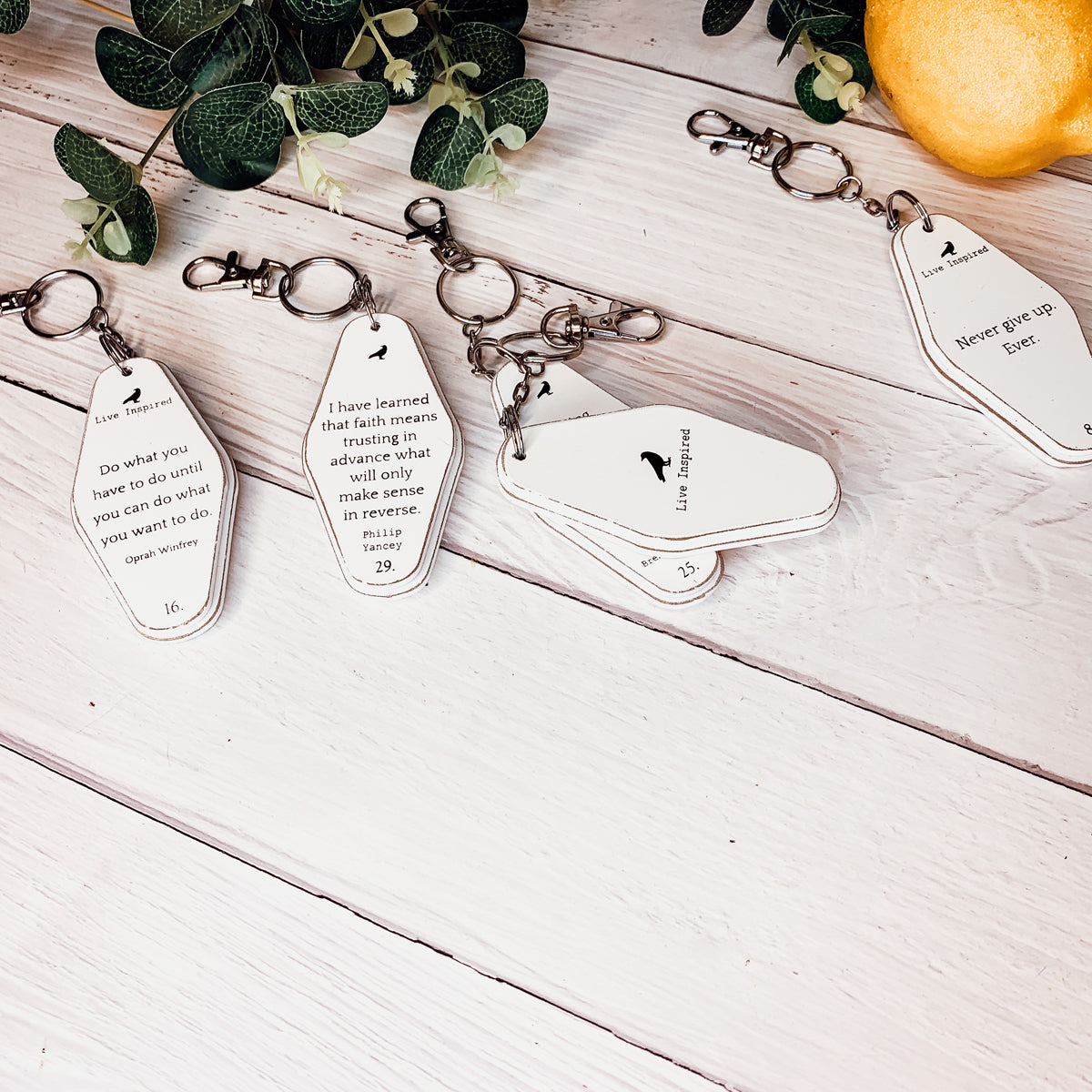 A collection of wooden key chains featuring various inspirational quotes, showcasing their durable design and stylish black and white colors.