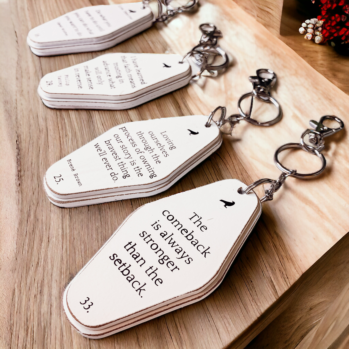 A collection of wooden key chains featuring various inspirational quotes, showcasing their durable design and stylish black and white colors.