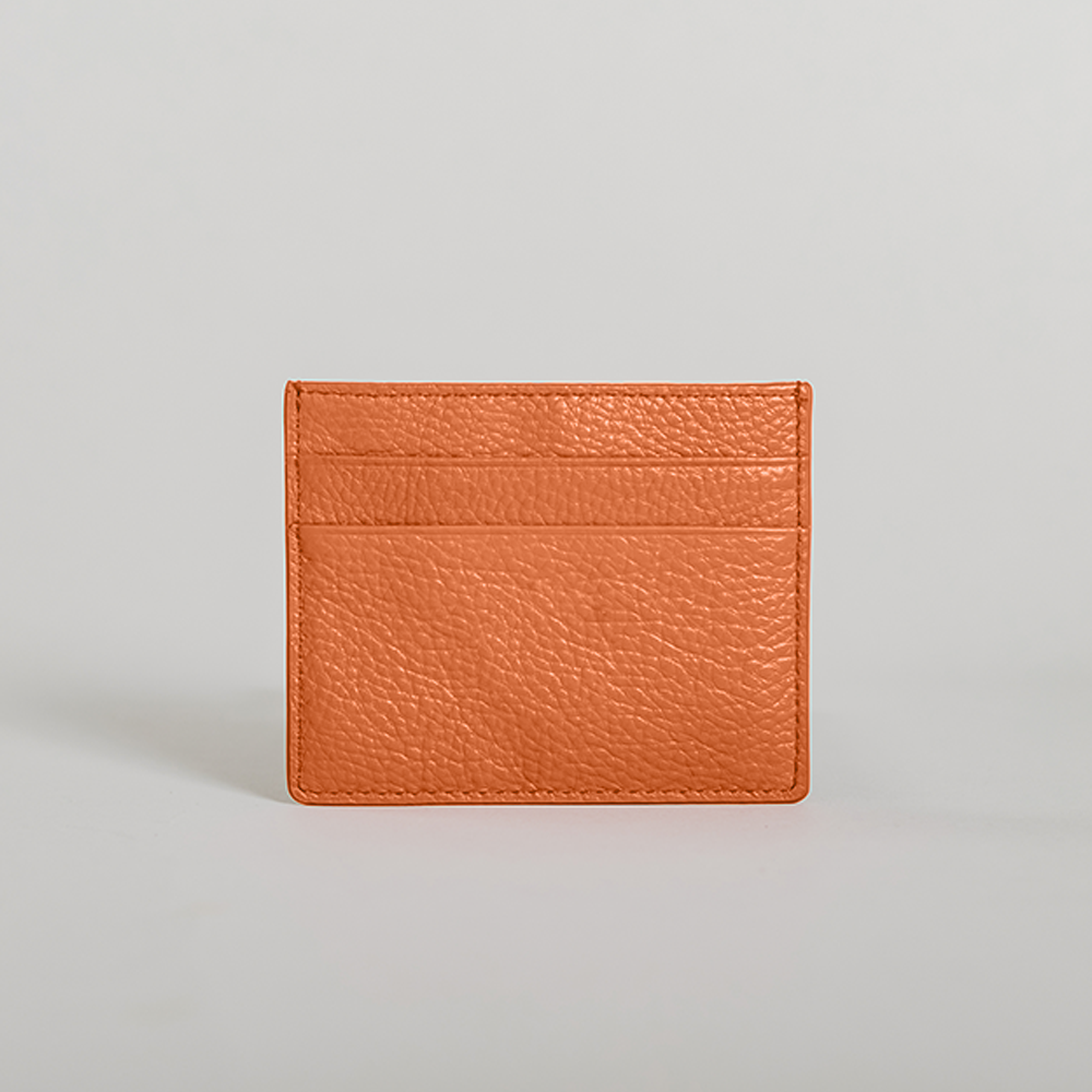 Stylish orange card holder made from saffiano leather with black suede detailing, featuring five card slots and a compact design.