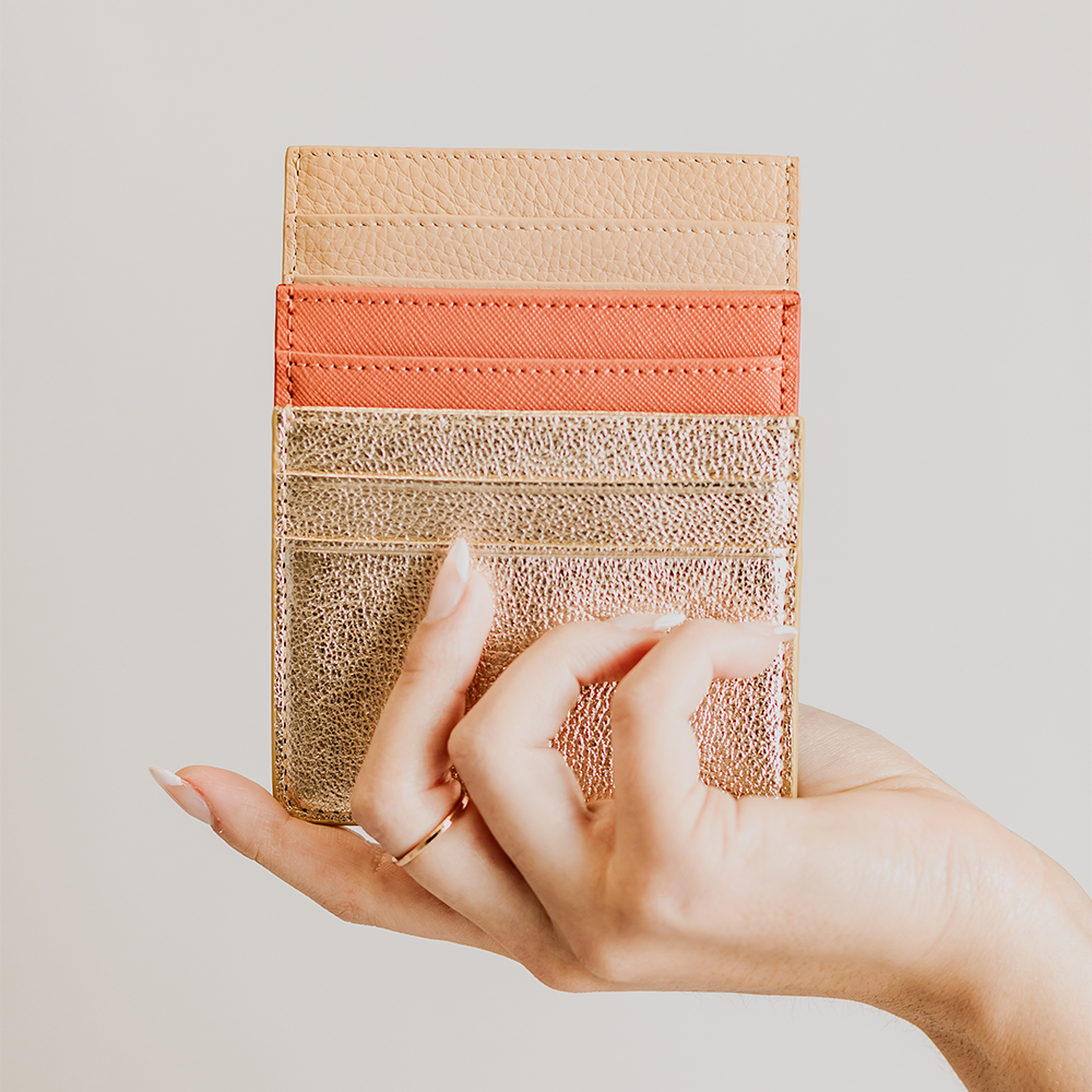 Stylish orange card holder made from saffiano leather with black suede detailing, featuring five card slots and a compact design.