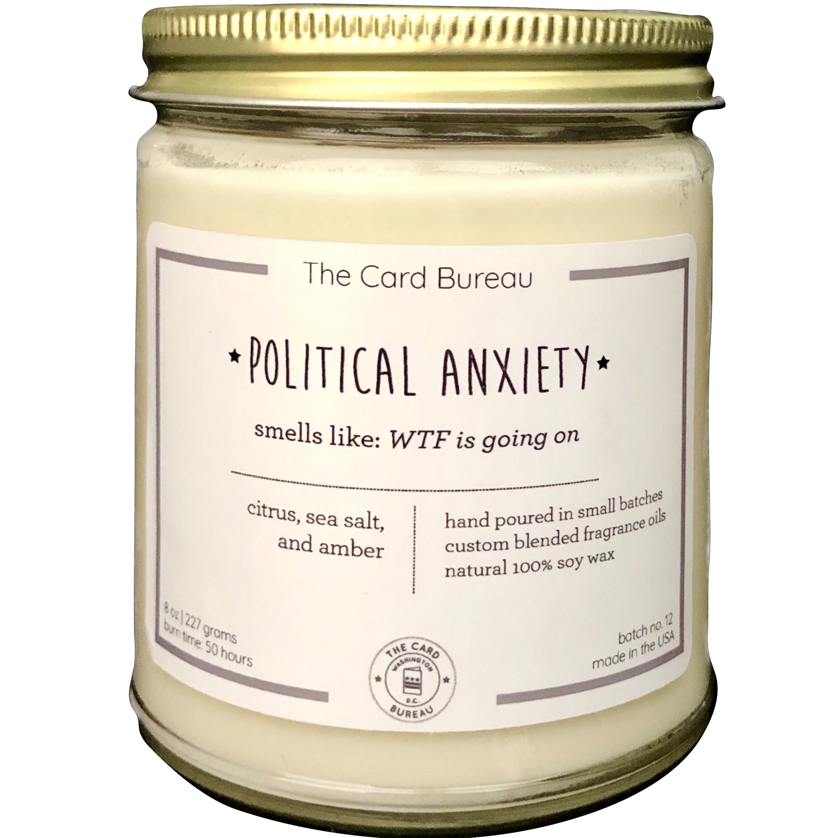 A hand-poured Political Anxiety Candle in a glass jar, featuring a citrus, sea salt, and amber scent, with a recyclable tin lid, showcasing its eco-friendly design.